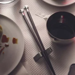Conjunto de dos palillos de ébano con soporte de inox Alessandro Mendini Alessi